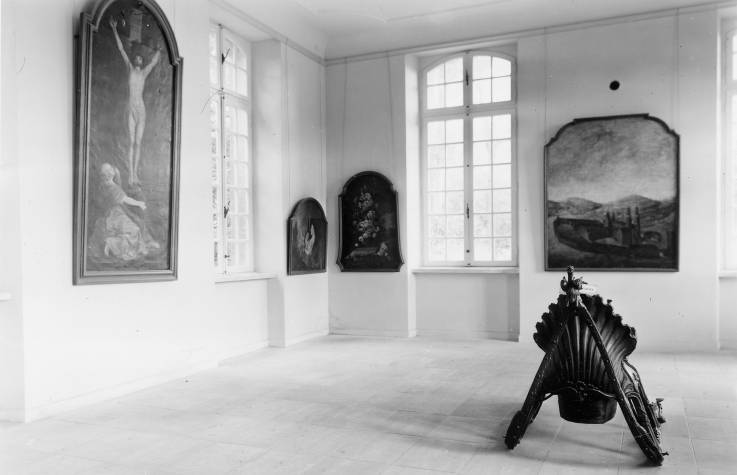 Tableaux provenant de la basilique et de l'abbaye d'Echternach avec, au centre de la pièce, un traineau 18e siècle, exposés en 1954.