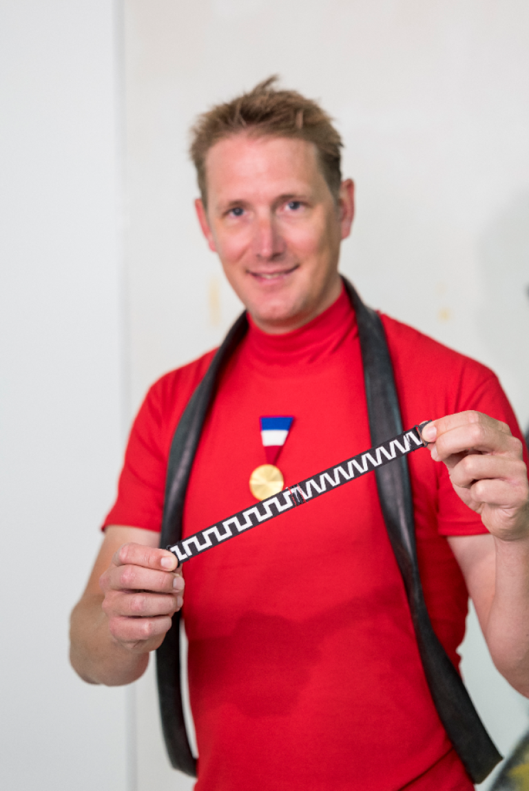 Andy Schleck tenant en main un ruban corporate du musée
